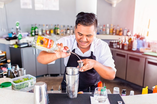 Jovem barman derramando cocktail em um bar, Phuket, Tailândia