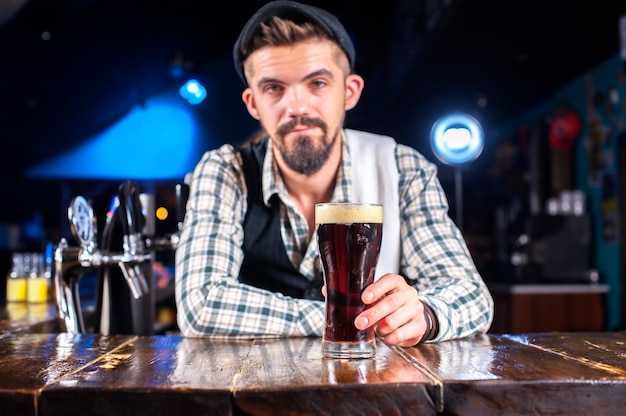 Jovem bartending servindo bebida alcoólica fresca nos copos enquanto estava perto do balcão do bar