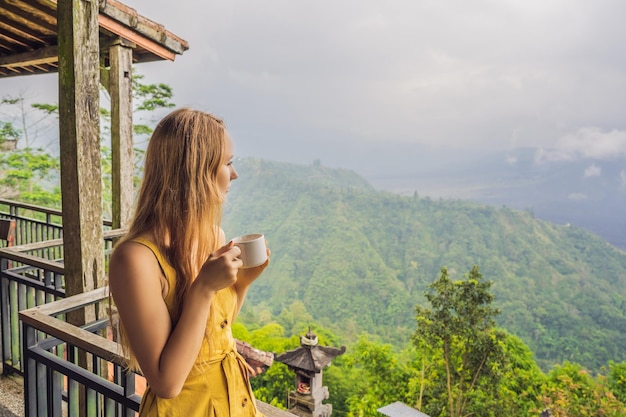 Jovem bebe café em um café nas montanhas