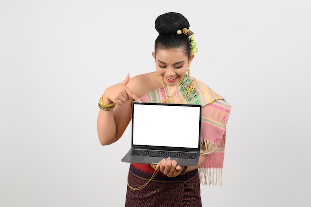 Jovem bela mulher em vestido nordeste segurando um laptop postando