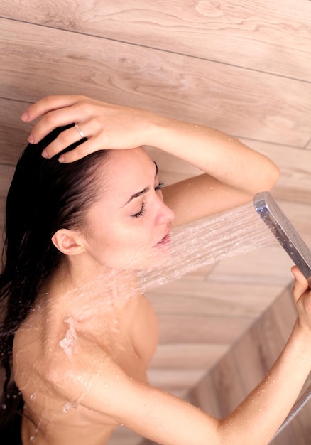 Foto jovem bela mulher tomando banho no banheiro