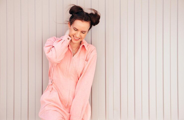 Foto jovem bela sorridente hipster mulher em moda verão macacão rosa ao ar livre na rua