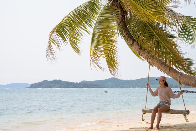 Jovem bela turista asiática relaxando na praia