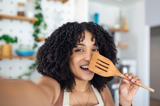 Jovem blogueira de comida afro-americana tirando uma selfie com um soldador