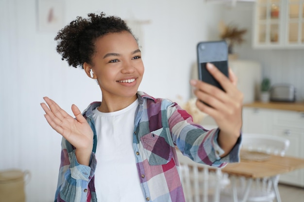 Jovem blogueira de raça mista mantém seguidores de saudação de chamada de vídeo de uso de smartphone na rede social