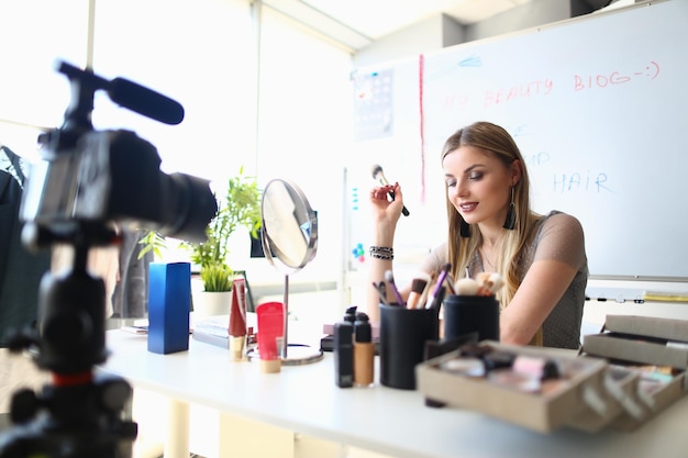 Jovem blogueira está gravando vídeo tutorial para blog sobre cosméticos