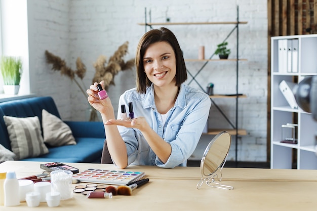 Jovem blogueira gravando um tutorial em vídeo para seu blog de beleza sobre cosméticos