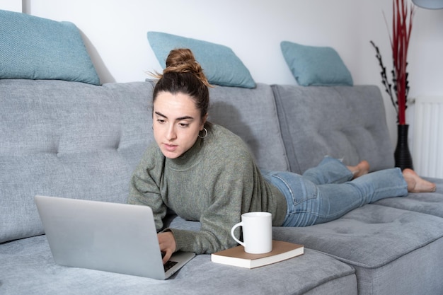 Jovem blogueiro criando conteúdo para mídias sociais enquanto estava deitado no sofá