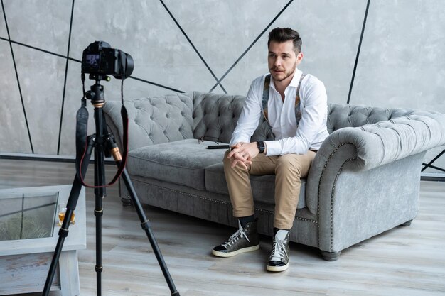 Jovem blogueiro gravando vídeo em casa.
