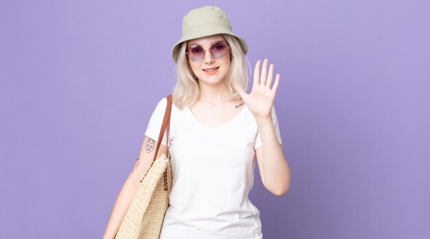 jovem bonita albina sorrindo e parecendo amigável, mostrando o número cinco. conceito de verão