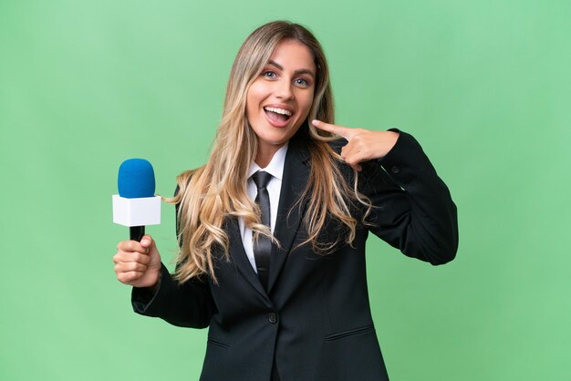 Jovem bonita apresentadora de tv uruguaia sobre fundo isolado, dando um polegar para cima gesto