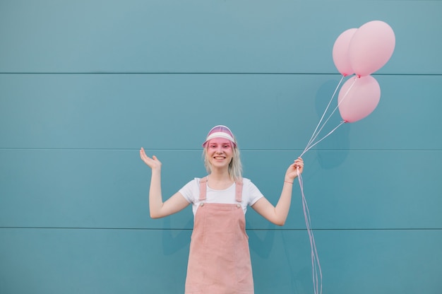 Jovem bonita com roupas rosa e balões