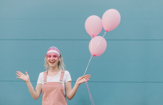 Jovem bonita com roupas rosa e balões