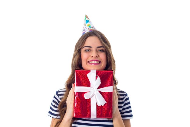 Jovem bonita em camiseta despojada e boné de celebração segurando presente vermelho com fita branca