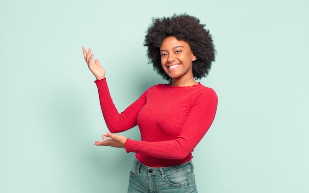 Jovem bonita negra apresentando um produto