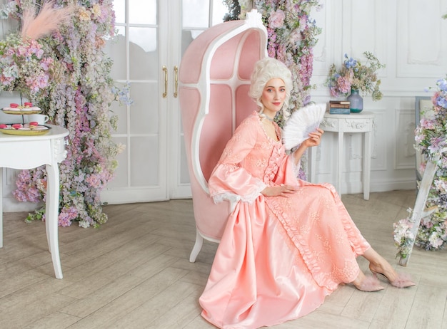 Jovem bonita vestida de vestido real rosa Marie Antoinette cosplay