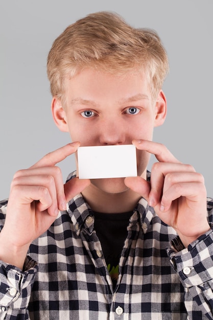 Jovem bonitão segurando um cartão em branco