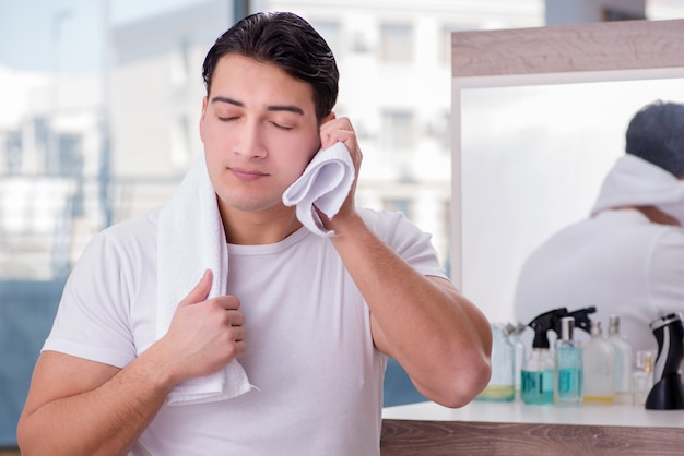 Jovem bonito, aplicar creme para o rosto