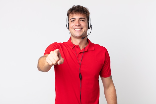 Jovem bonito apontando para a câmera escolhendo você. conceito de telemarketing