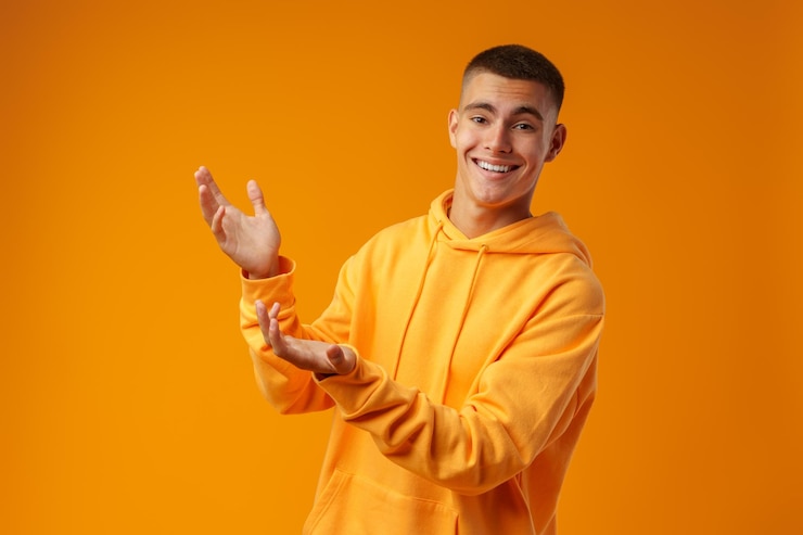 Foto jovem bonito apontando para copiar o espaço em um fundo amarelo