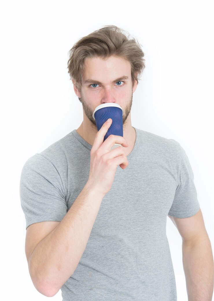 Foto jovem bonito beber café para viagem ou xícara de chá isolada no fundo branco