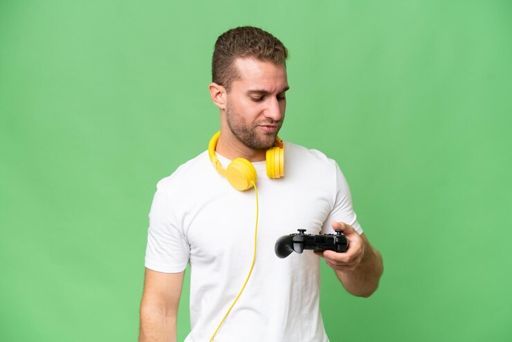 Foto jovem bonito brincando com um controlador de videogame isolado em fundo croma verde com expressão triste