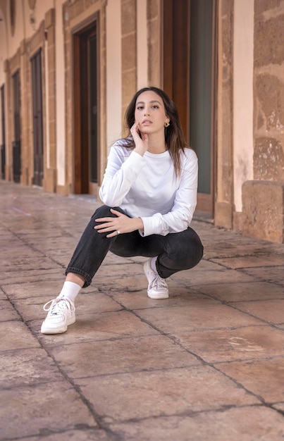 Jovem bonito cabelo castanho confiante mulher caucasiana posando outdorr