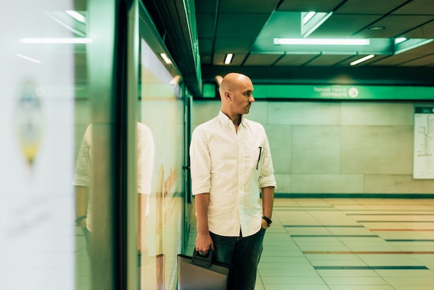 Jovem, bonito, caucasiano, careca, homem negócios, esperando, tubo, em, a, subterrâneo, estação