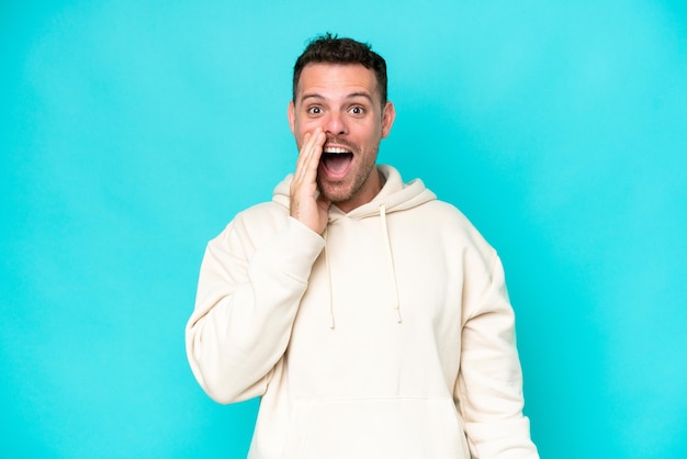 Foto jovem bonito caucasiano isolado em fundo azul com surpresa e expressão facial chocada