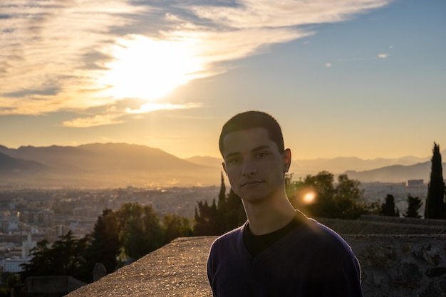 Jovem bonito com atitude positiva posando para a câmera com o mar ao fundo