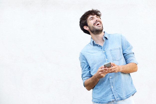 Foto jovem bonito com barba a segurar um telemóvel.