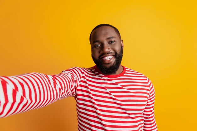 Jovem bonito com barba fazendo selfie um sorriso cheio de dentes