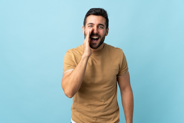 Jovem bonito com barba gritando com a boca bem aberta