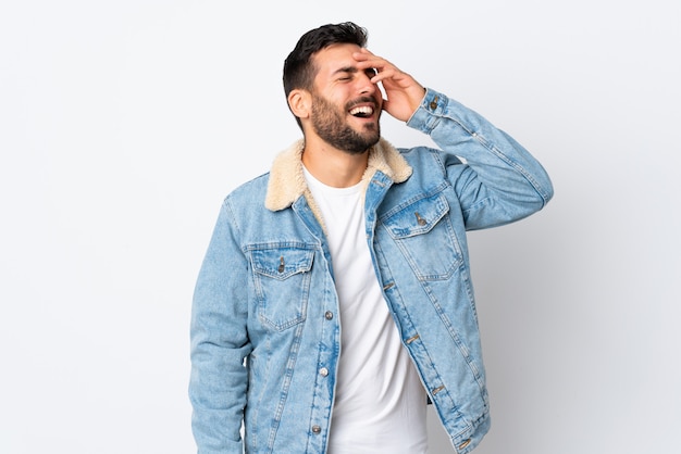 Jovem bonito com barba isolada na parede branca, sorrindo muito