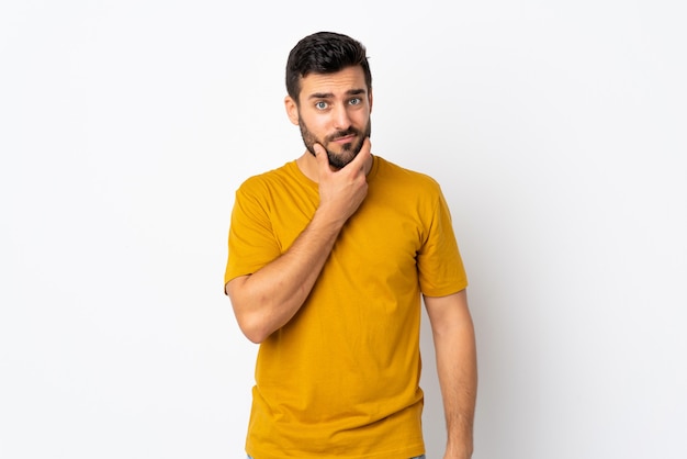 Jovem bonito com barba isolada no branco, tendo dúvidas