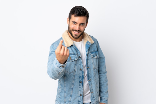 Jovem bonito com barba isolada no fundo branco fazendo gesto de aproximação