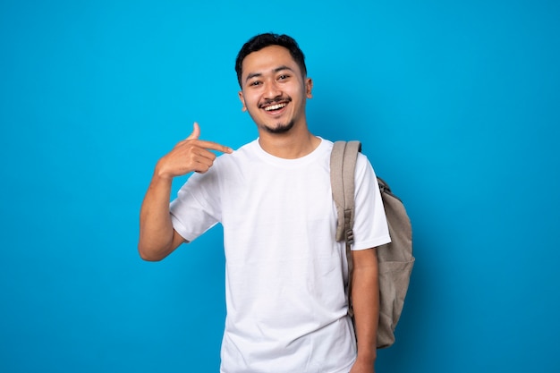 Jovem bonito com barba rala sorrindo com confiança sobre fundo azul