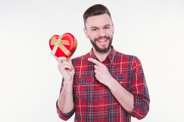 Jovem bonito com barba segurando presente ou caixa de presente nas mãos feliz aniversário ou dia dos namorados