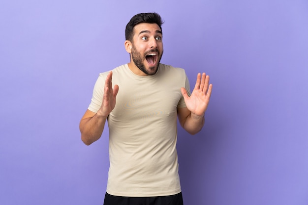 Jovem bonito com barba sobre fundo isolado e expressão facial surpresa