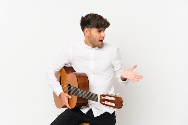 Foto jovem bonito com guitarra com expressão facial de surpresa