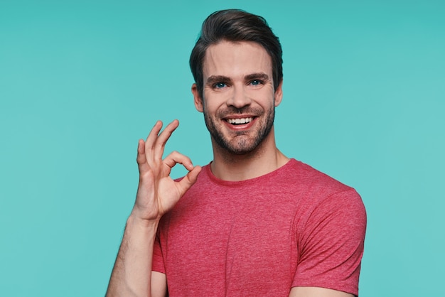 Foto jovem bonito com roupas casuais, olhando para a câmera e gesticulando