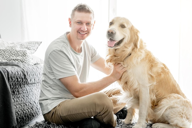 Jovem bonito com seu cachorro golden retriever