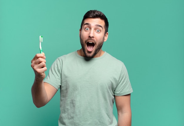 Jovem bonito com uma escova de dentes