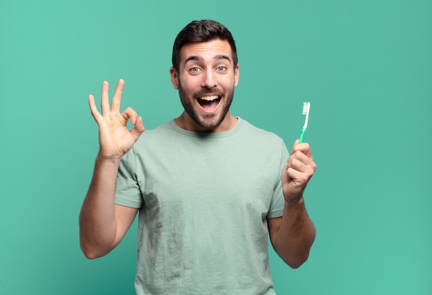 Jovem bonito com uma escova de dentes.