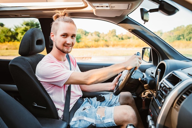 Jovem bonito confiante dirigindo viagem de carro