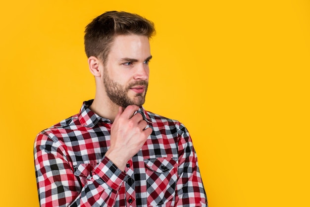 Jovem bonito de camisa quadriculada tem cerdas no rosto cabeleireiro