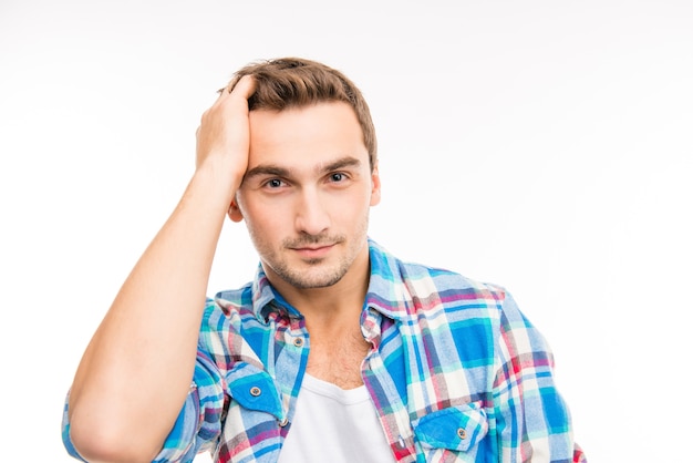 Jovem bonito e alegre penteando o cabelo com os dedos