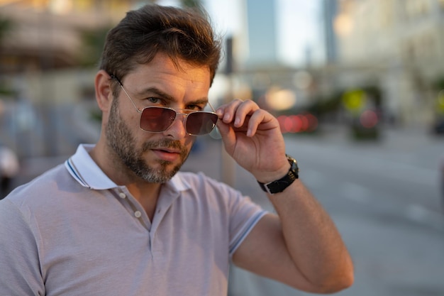 Jovem bonito em camiseta polo clássica na rua, bonito e confiante modelo hipster pos