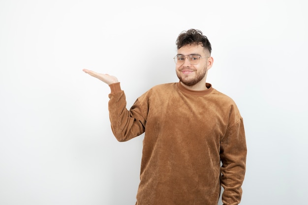 jovem bonito em pé e segurando o espaço aberto.