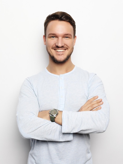 Jovem bonito em roupas casuais inteligentes, olhando para a câmera